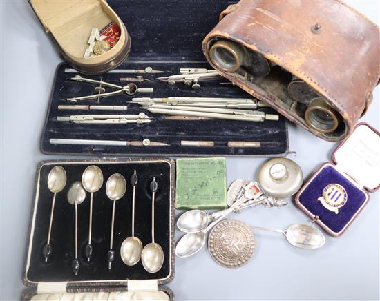 A pair of military binoculars, badges, a compass, two silver spoons etc